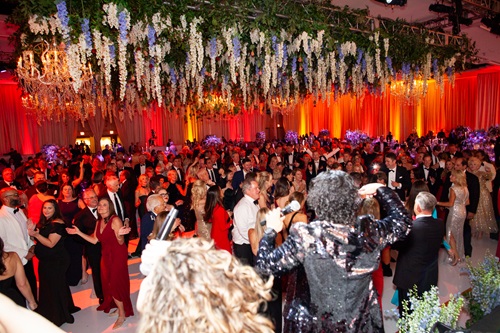 Photo of crowded dance floor with flowers hanging from ceiling